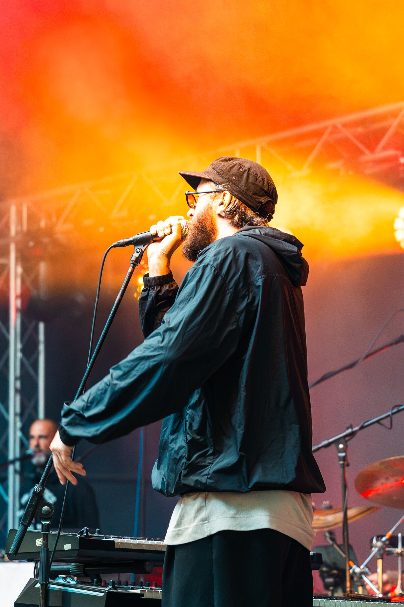 Rapper u mikrofonu před oranžovým světlem z rampy