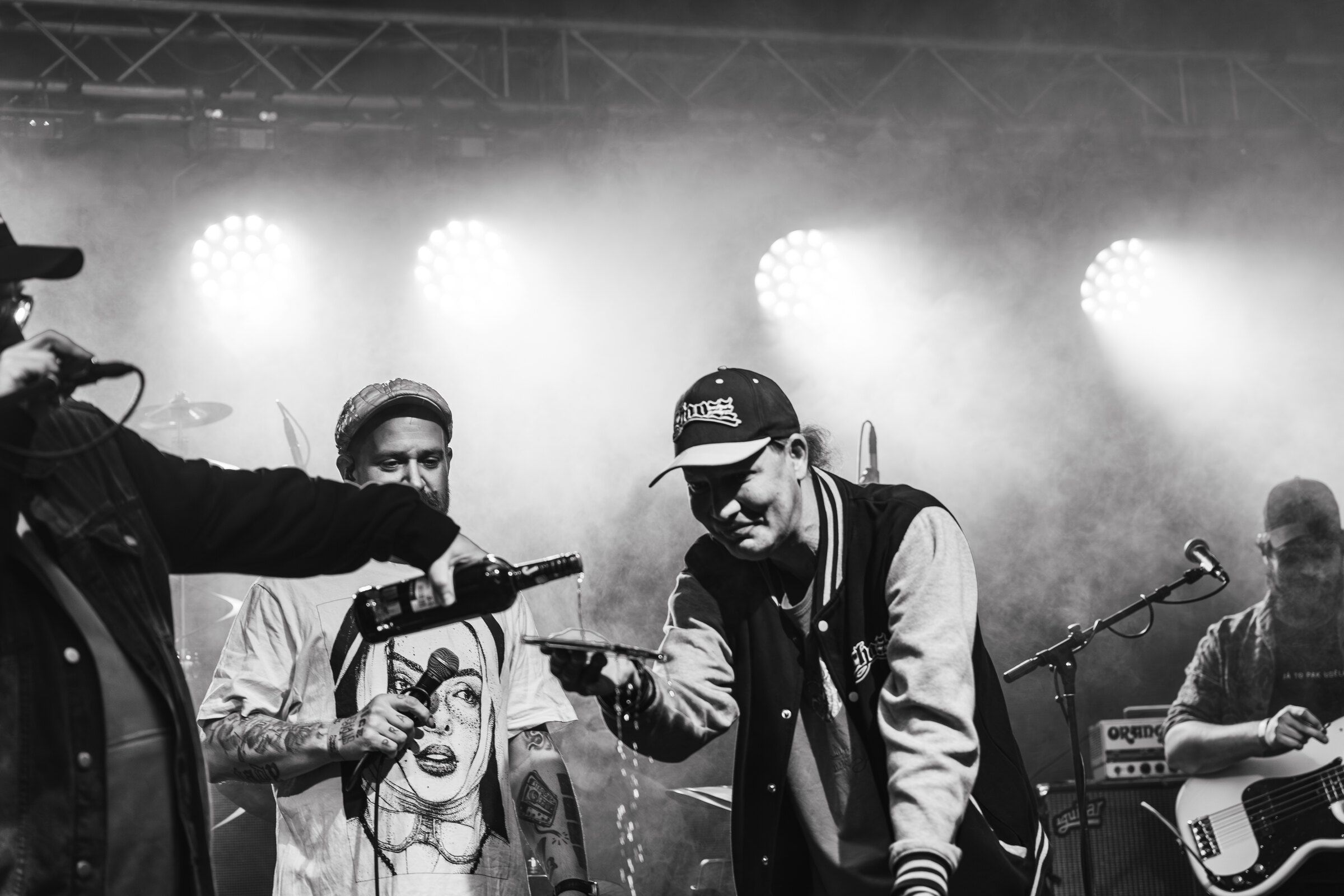Černobílý záběr dvou rapperů na zakouřeném pódiu