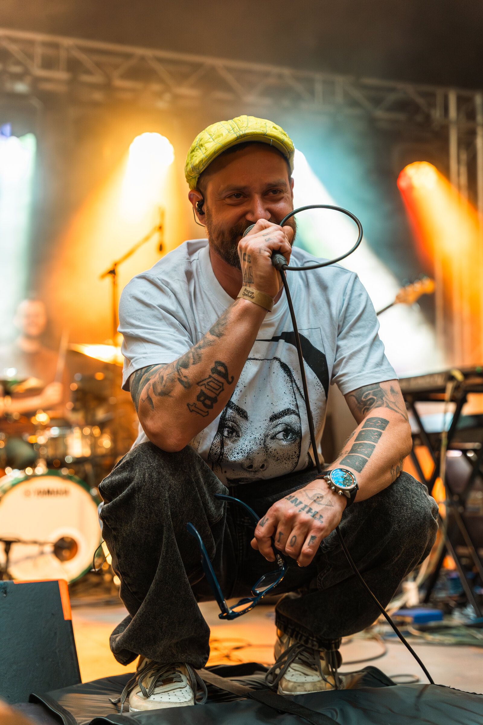 Rapper v podřepu na kraji pódia se zavřenýma očima