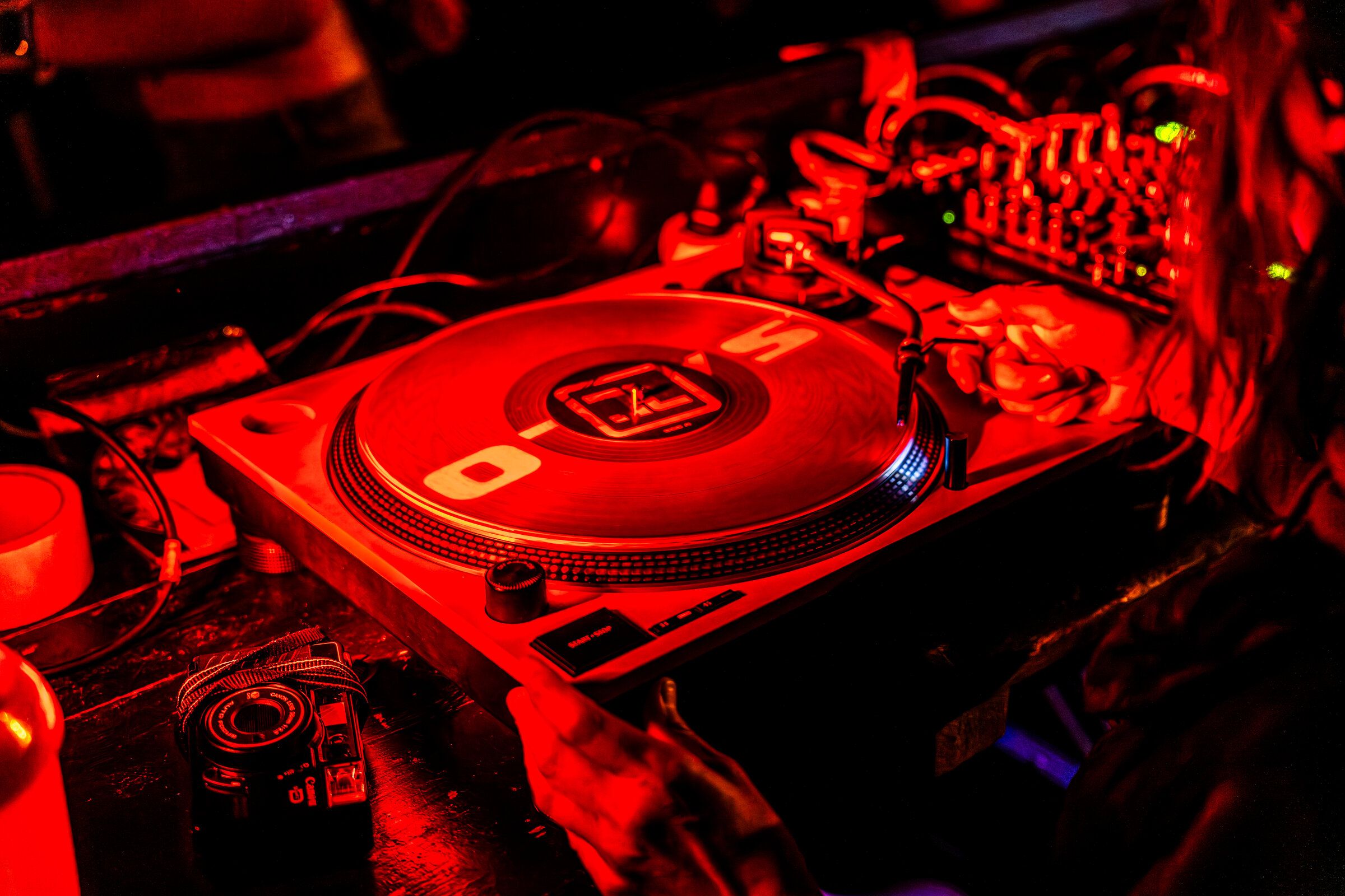 Gramofon a mixpult v červeném světle