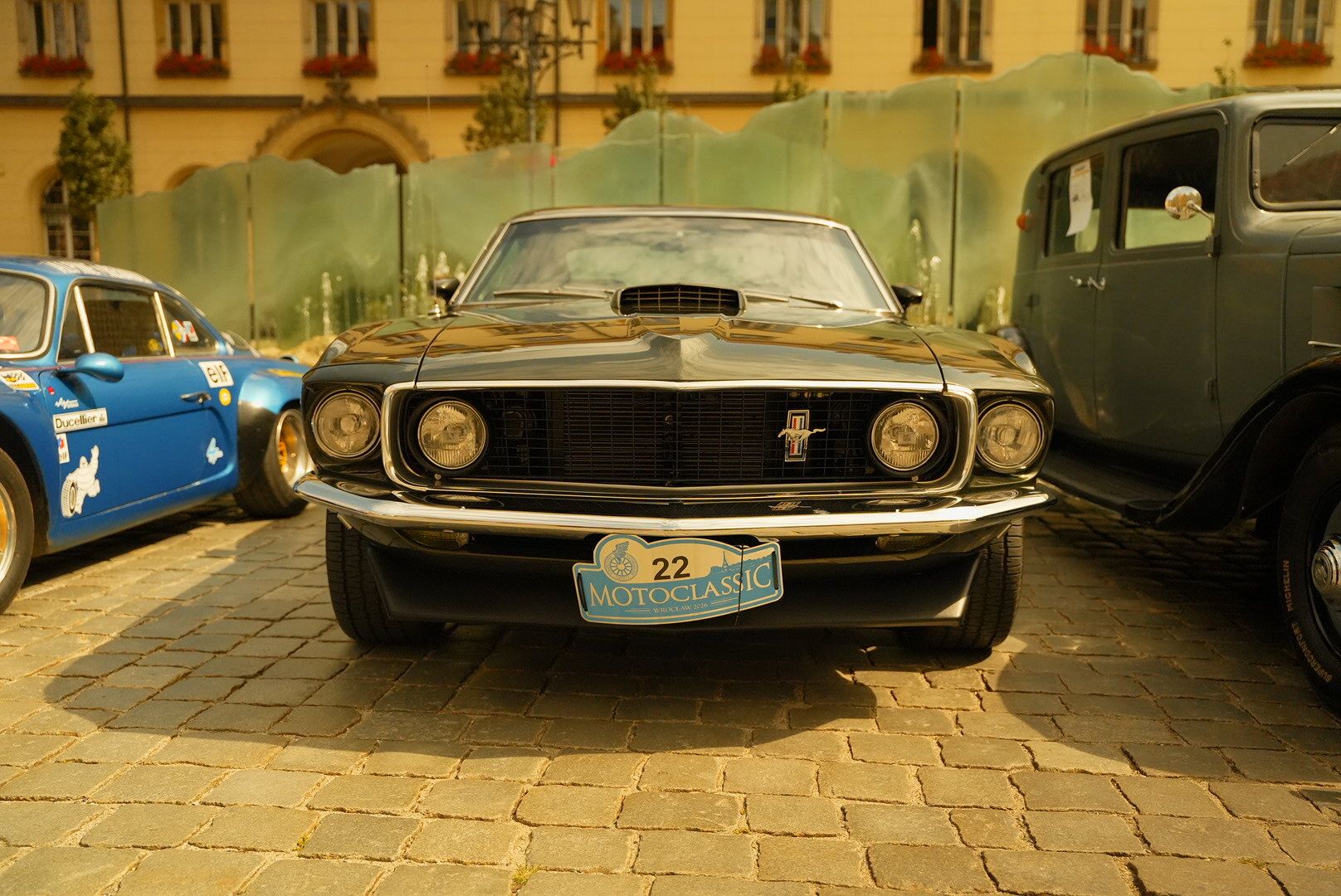 Černý Ford Mustang na dlažbě mezi veterány